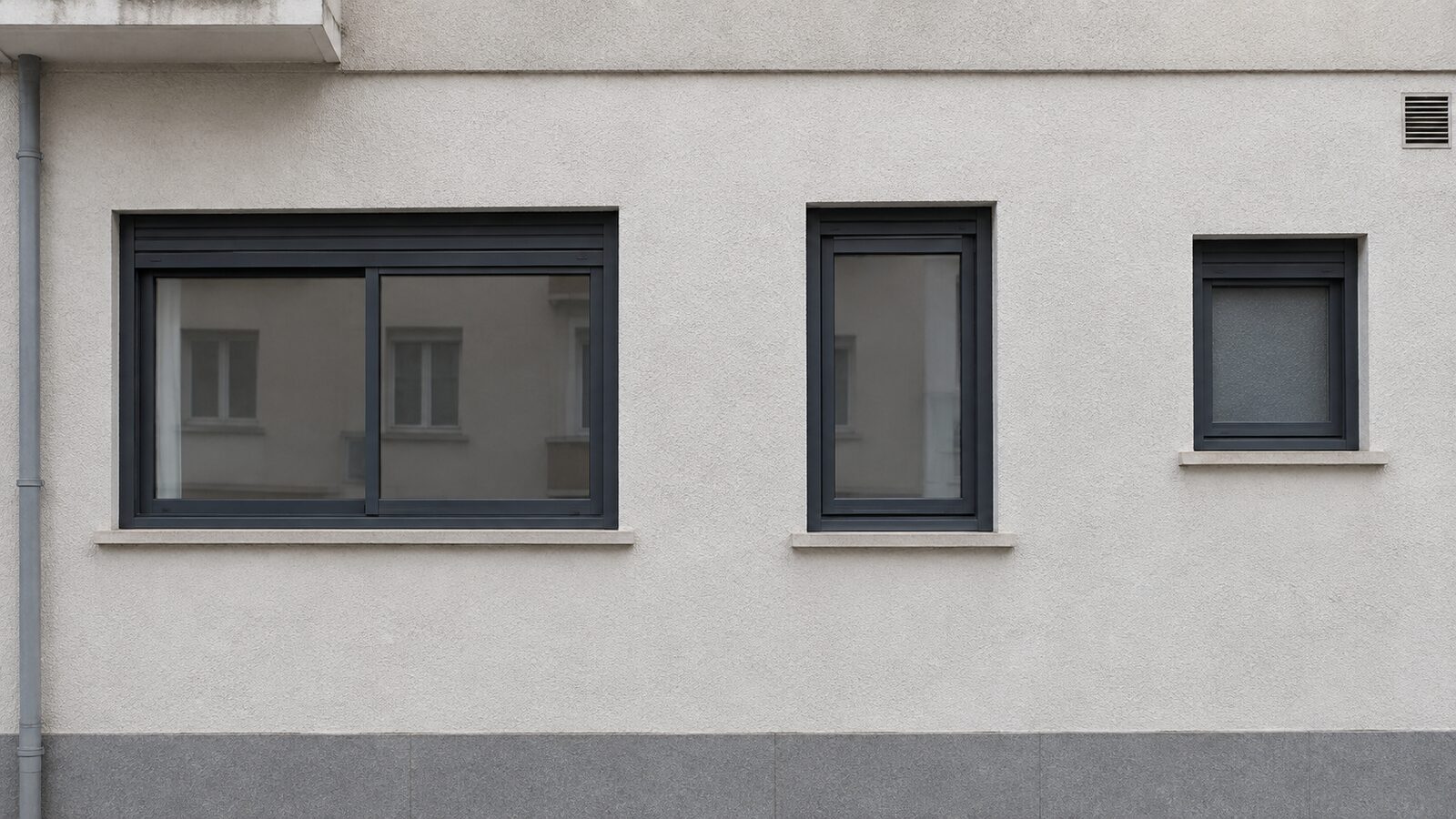 Tres ventanas de aluminio en la misma fachada, cada una con una apertura